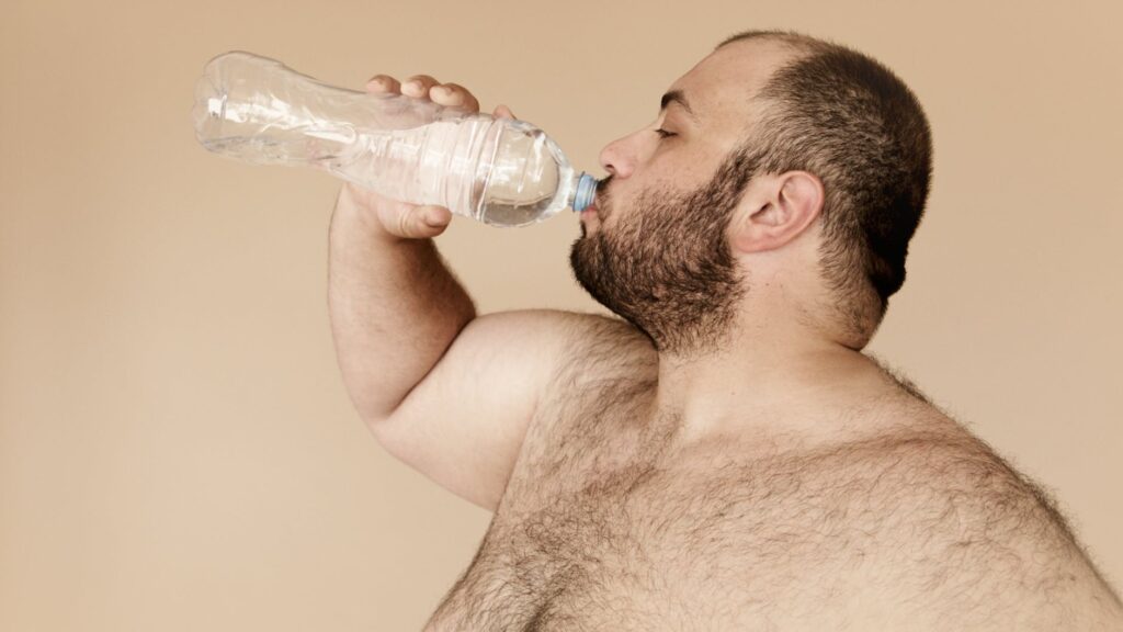 man drinking from clear plastic bottle Why Are There Bubbles In My Water Bottle
